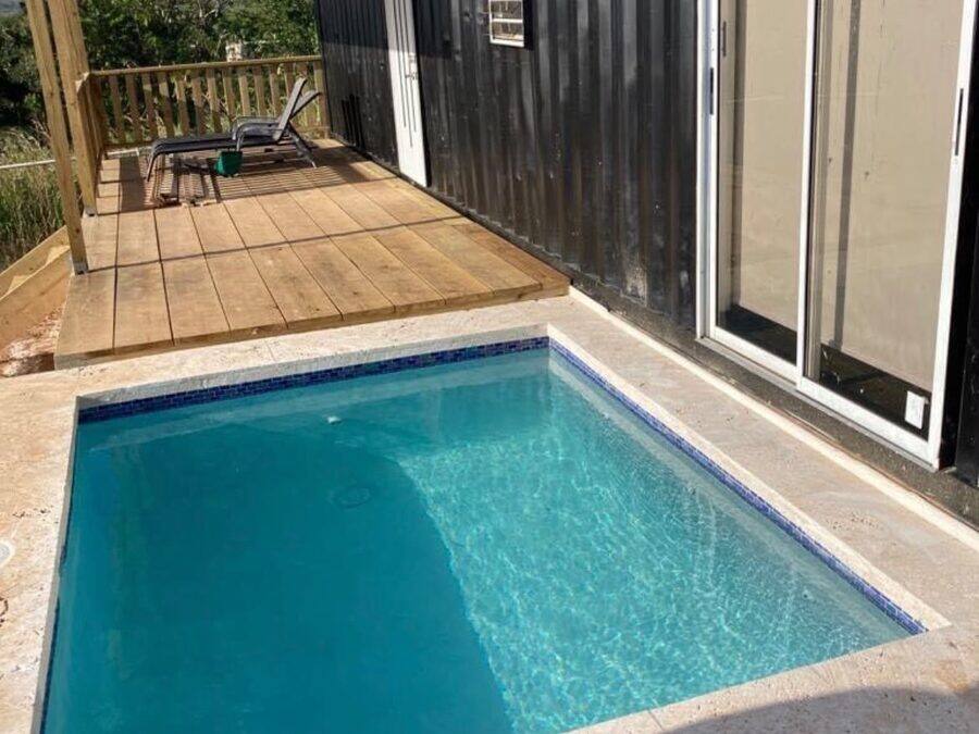Piscina integrada a deck de madera en residencia moderna