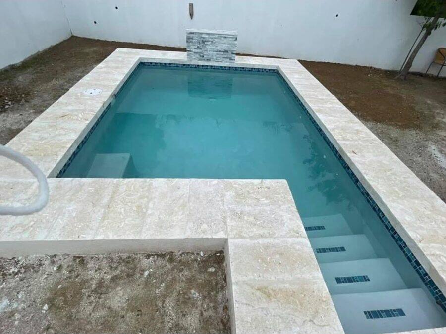 Jacuzzi elevado con cascada de piedra sobre la piscina principal