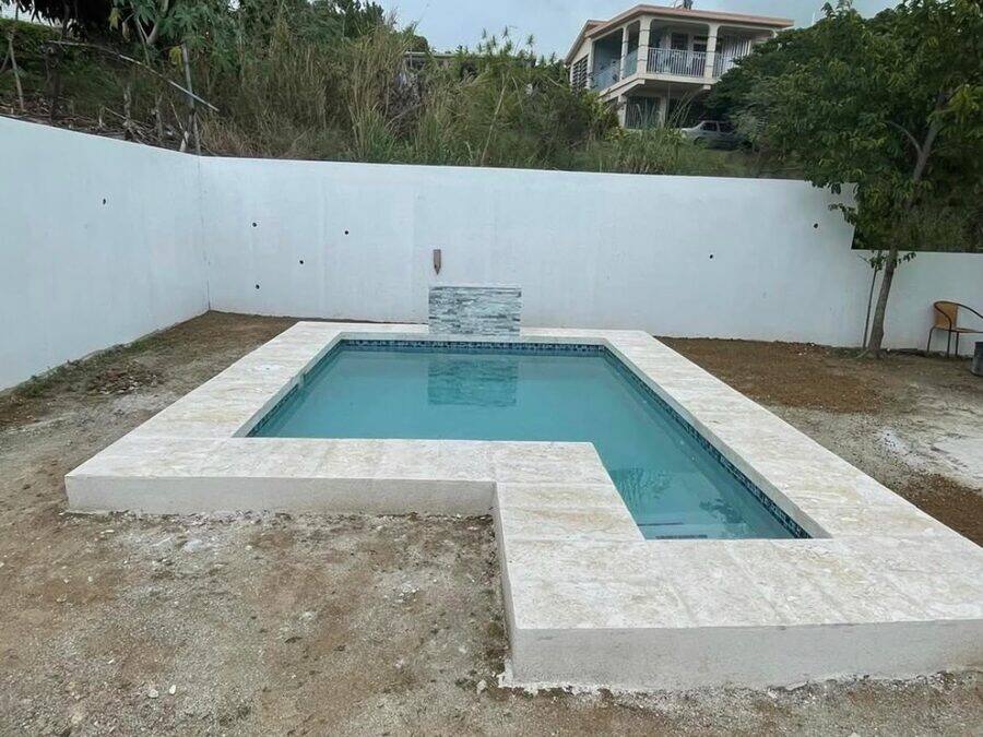 Piscina compacta con sundeck y muro perimetral en construcción