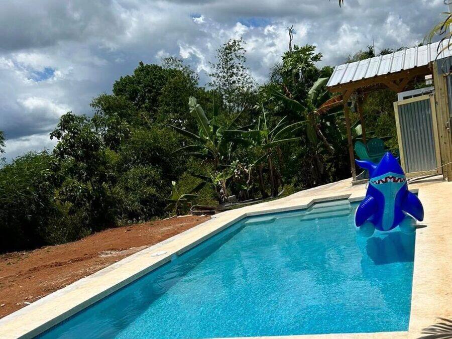 Piscina alargada con vista al monte, terreno en preparación