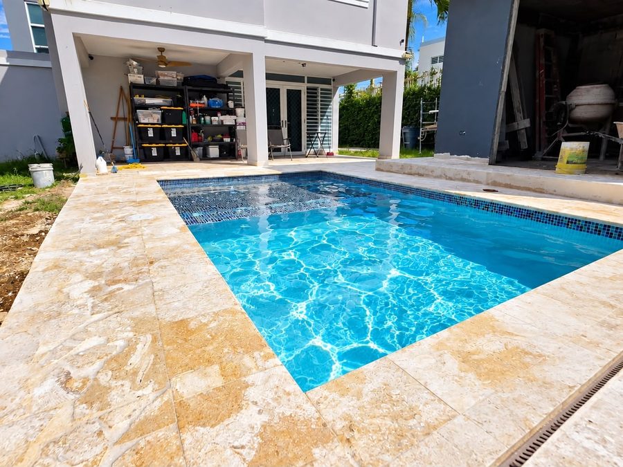 Piscina con aceras de travertino junto a la residencia