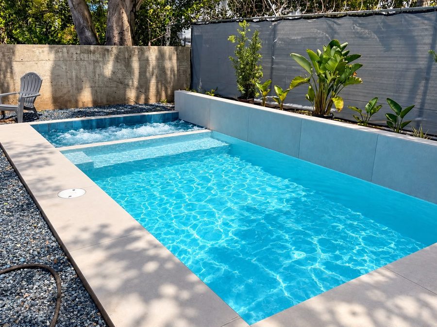 Piscina con muro elevado y jardín tropical